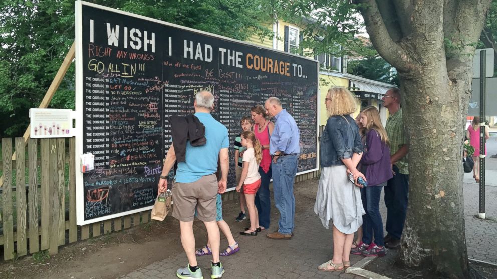 A crowd gathers by the Courage Wall in Alexandria, Virginia. 