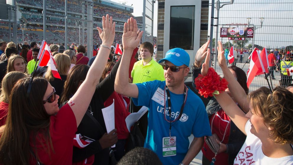 PHOTO: UNICEF Canada team members high-five amongst themselves and with fans arriving for the Women's World Cup Soccer friendly match between Canada and England at Tim Horton's Field in Hamilton, Ontario, May 29, 2015.