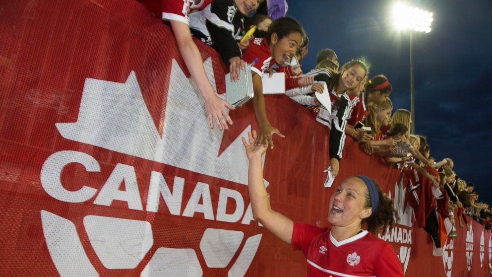 PHOTO: Carmelina Moscato high fives with fans after Team Canada's win over England in a Women's World Cup Soccer friendly match between Canada and England at Tim Horton's Field in Hamilton, Ontario, May 29, 2015.
