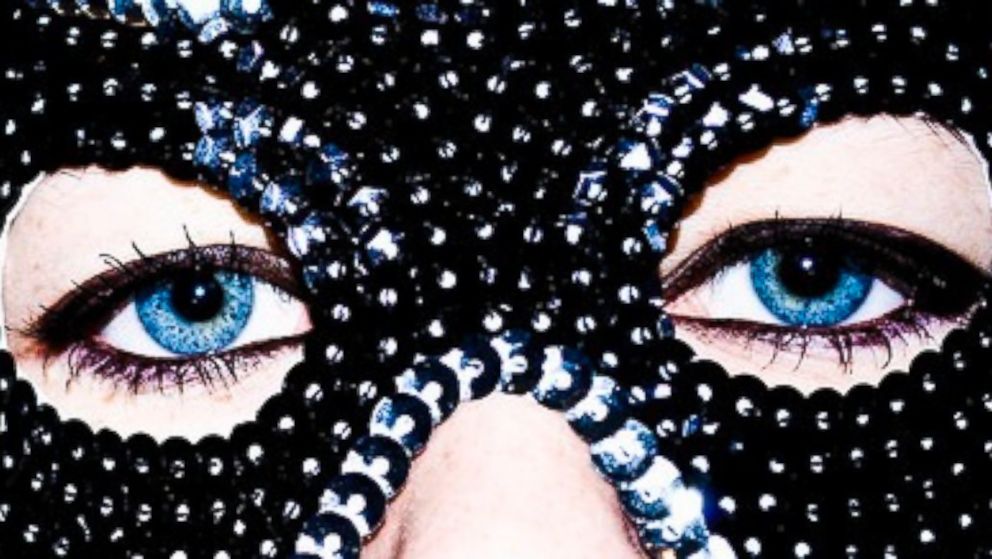 A woman's eyes appear behind a mask.
