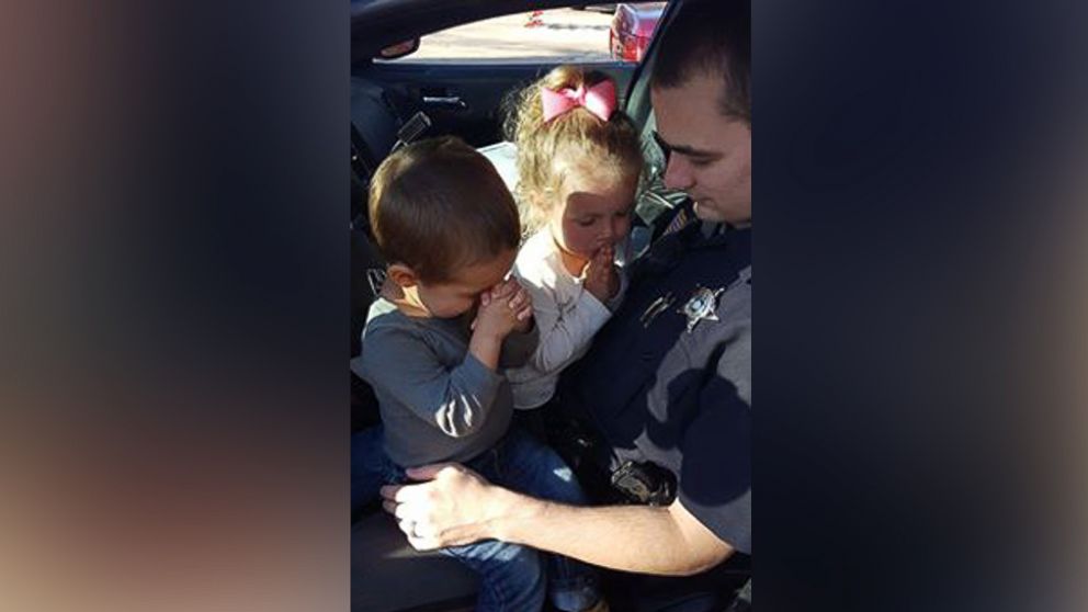 Deputy Jordan Perkins was photographed praying with his children Miya, 3, and Mason, 1, March 22, 2016. 