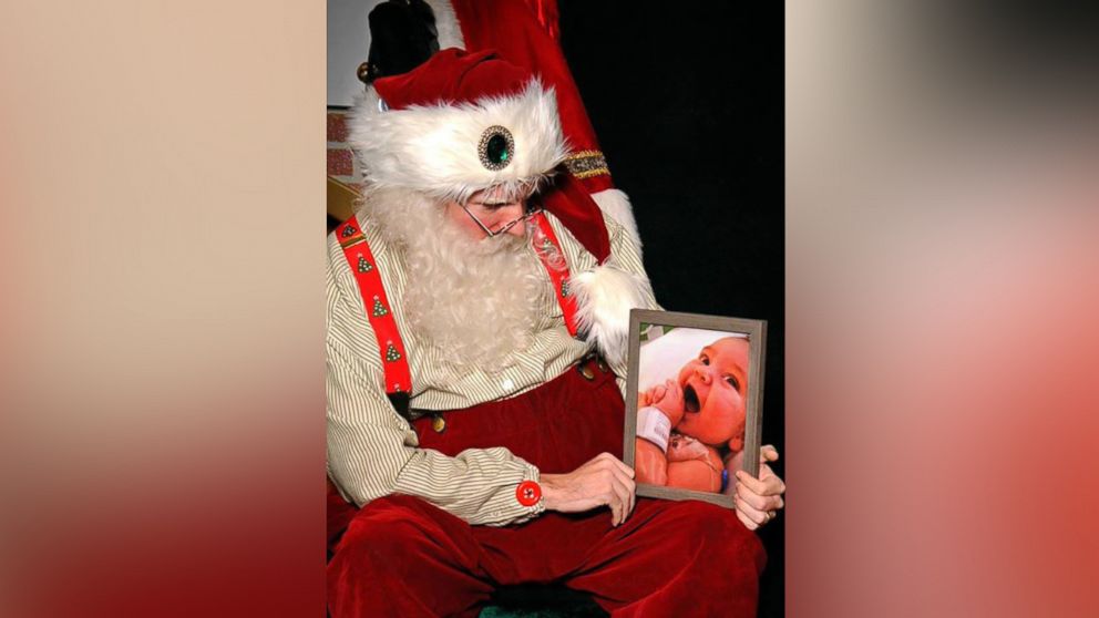 Caleb Ryan Sigmon works as a mall Santa and was asked by a dad to hold this photo. 
