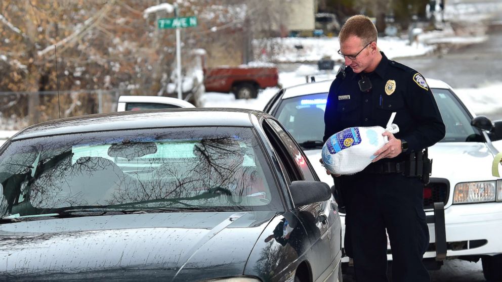PHOTO: Billings, Montona police officer Eric Schnelbach gives a frozen turkey and a warning to Larry Riddle and his daughter Amber after they were pulled over for a minor traffic violation. Billings businessman Steve Goutanis donated the turkeys.