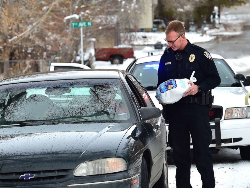PHOTO: Billings, Montona police officer Eric Schnelbach gives a frozen turkey and a warning to Larry Riddle and his daughter Amber after they were pulled over for a minor traffic violation. Billings businessman Steve Goutanis donated the turkeys.