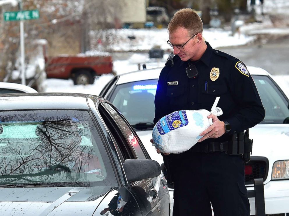 PHOTO: Billings, Montona police officer Eric Schnelbach gives a frozen turkey and a warning to Larry Riddle and his daughter Amber after they were pulled over for a minor traffic violation. Billings businessman Steve Goutanis donated the turkeys.