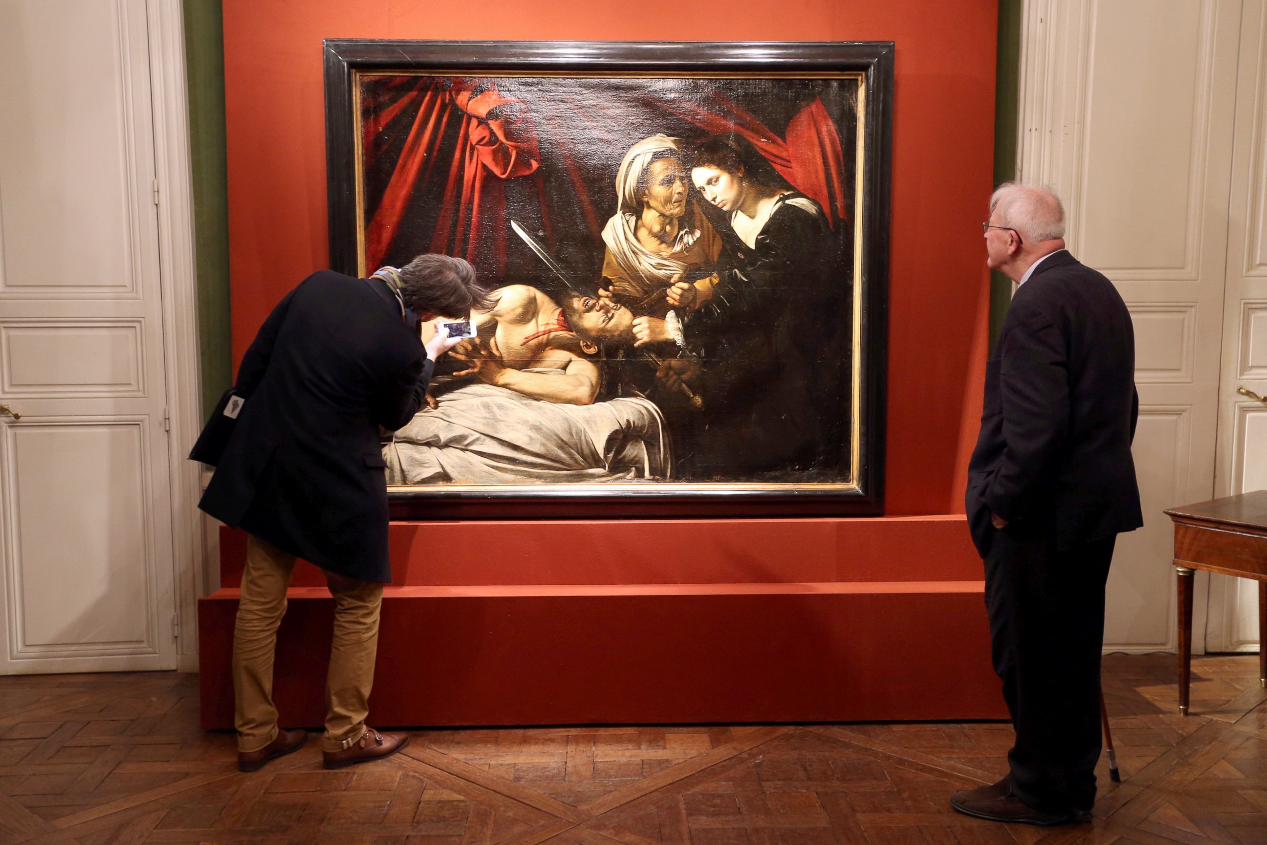 PHOTO: Visitors looks at a painting entitled "Judith Beheading Holofernes" during its presentation in Paris,  April 12, 2016.