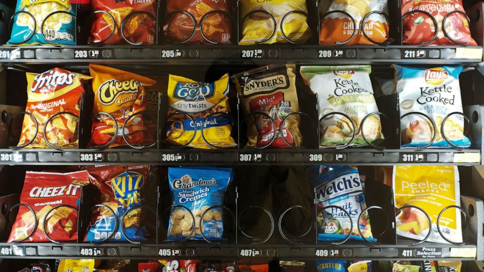 This Saturday, Sept. 7, 2019 photo shows items in a vending machine in New York. Americans are addicted to snacks, and food experts are paying closer attention to what that might mean for health and obesity. (AP Photo/Patrick Sison)
