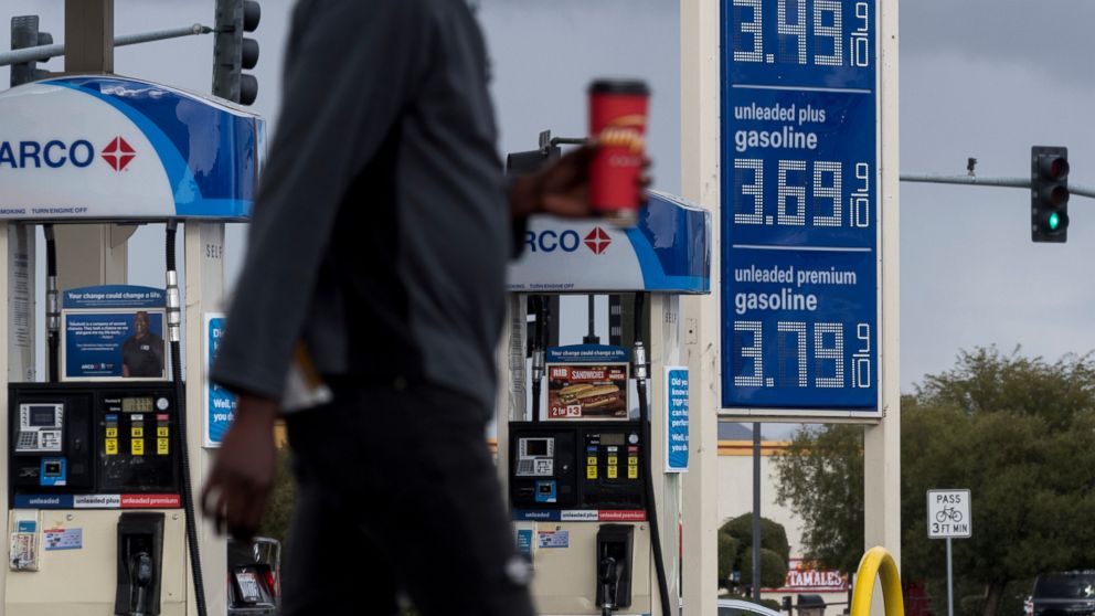 FILE - In this Nov. 29, 2018, file photo, a person walks past a gas station around Victorville, Calif. The average U.S. price of regular-grade gasoline has dropped 12 cents a gallon (3.8 liters) over the past three weeks to $2.31. Industry analyst Tr
