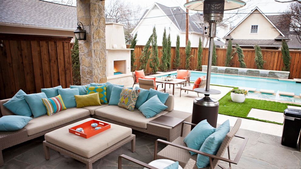 This undated photo shows an outdoor space at a home in Texas designed by Abbe Fenimore, founder of Studio Ten 25. With the addition of an outdoor fireplace and a standing space heater, a backyard can be focused on the swimming pool during the summer 