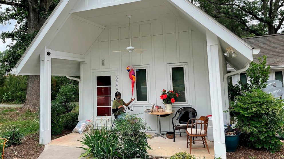 In this photo provided by The Rev. Lisa G. Fishbeck, Nathaniel “Pee Wee” Lee sits outside his home in Chapel Hill, N.C., on May 23, 2022. Fischbeck led the Episcopal Church of the Advocate when it added three one-bedroom units on its 15-acre campus. 