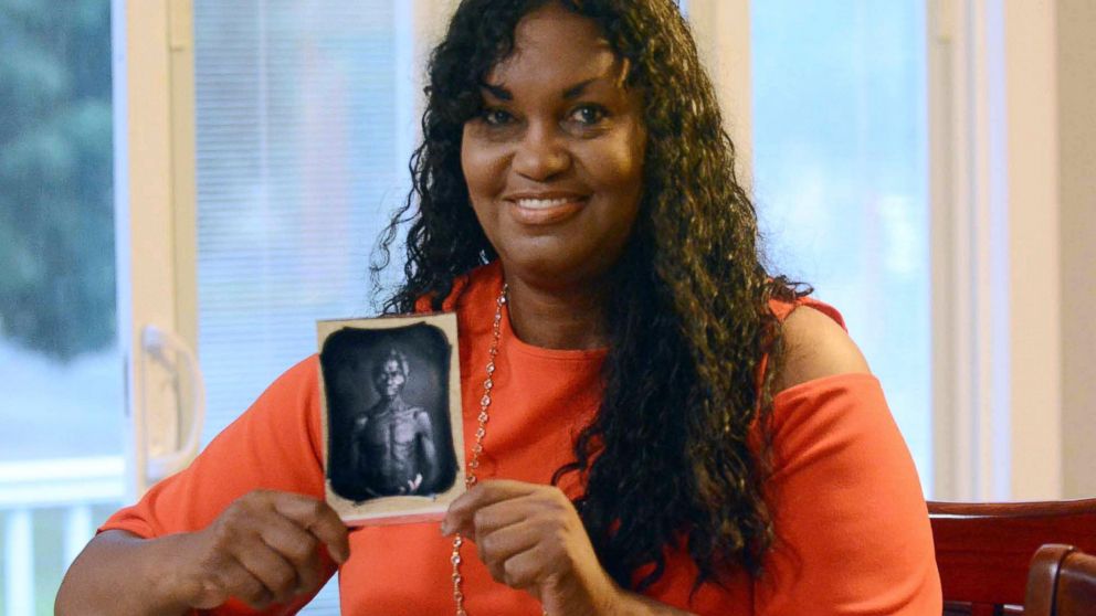 In this July 17, 2018, photo, Tamara Lanier holds an 1850 photograph of Renty, a South Carolina slave who Lanier said is her family's patriarch, at her home in Norwich, Conn. The portrait was commissioned by Harvard biologist Louis Agassiz, whose ide