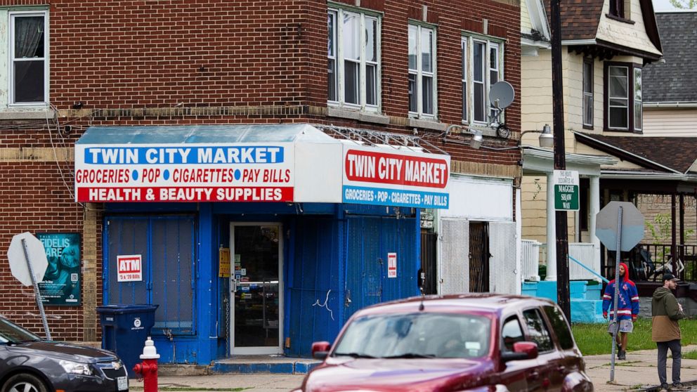 People walk and drive by Twin City Market, four blocks east of Tops Friendly Market, on Tuesday, May 17, 2022, in Buffalo, N.Y. (AP Photo/Joshua Bessex)