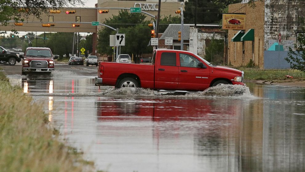 A vehicle drives through a flooded section of Muskingum Avenue on Saturday, April,13, 2019, in Odessa, Texas. (Jacob Ford/Odessa American via AP)