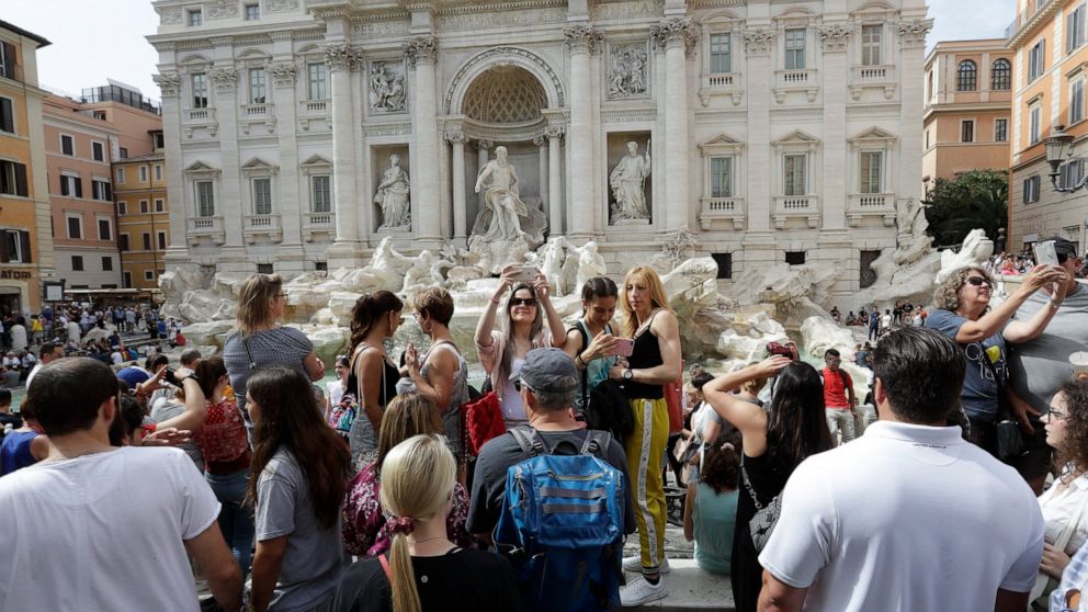 Tourists gather in front of the Trevi fountain, in Rome, Friday, June 7, 2019. Tired of ad hoc bans on ill behavior by tourists, Rome has converted its temporary crackdowns into one big law. The city announced Friday that the city council had a day e