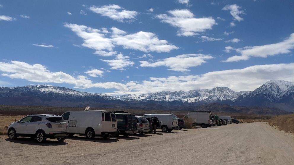 In this Wednesday, March 18, 2020 photo provided by Paula Flakser cars line along a dirt road near rock climbing spots outside Bishop, Calif. Local residents including Flakser were angry when hundreds of people from Los Angeles arrived in Bishop last