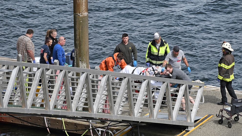 Emergency response crews transport an injured passenger to an ambulance at the George Inlet Lodge docks, Monday, May 13, 2019, in Ketchikan, Alaska. The passenger was from one of two float planes reported down in George Inlet early Monday afternoon a