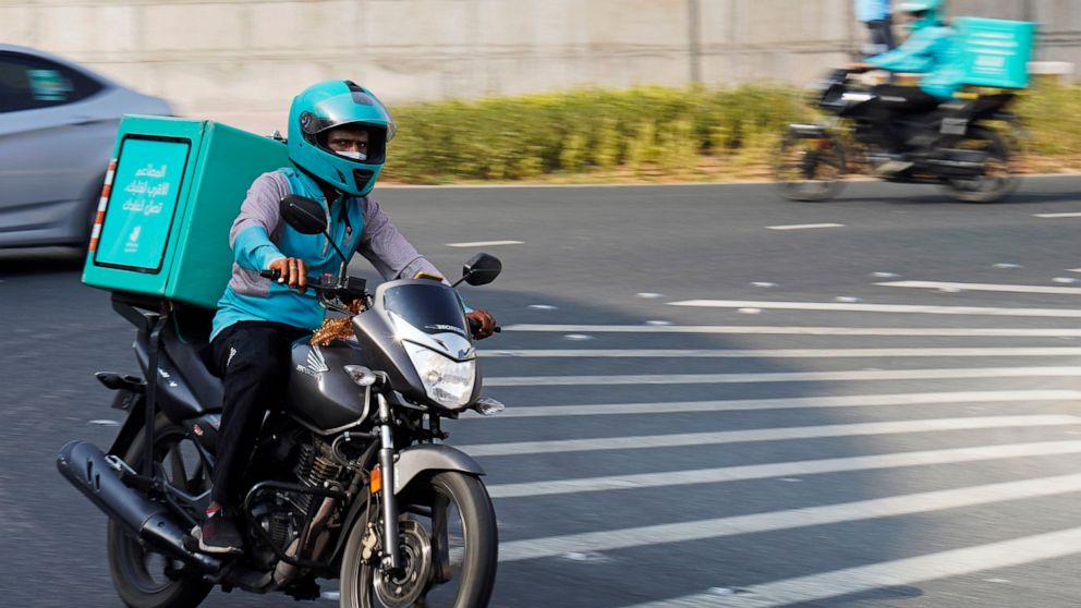 A delivery driver for the app Deliveroo speeds through a roundabout, in Dubai, United Arab Emirates, Thursday, Sept. 9, 2021. Advocates and workers say that casualties among food delivery riders are mounting in the city of Dubai, as the pandemic acce