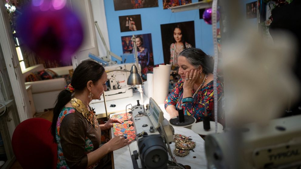 Roma sisters Helena, left, and Erika Varga work on a production in their fashion studio, Romani Design, in Budapest, Hungary, Sunday, Dec. 12, 2021. Romani Design, a fashion studio in Hungary, is challenging the centuries-old stereotypes faced by the