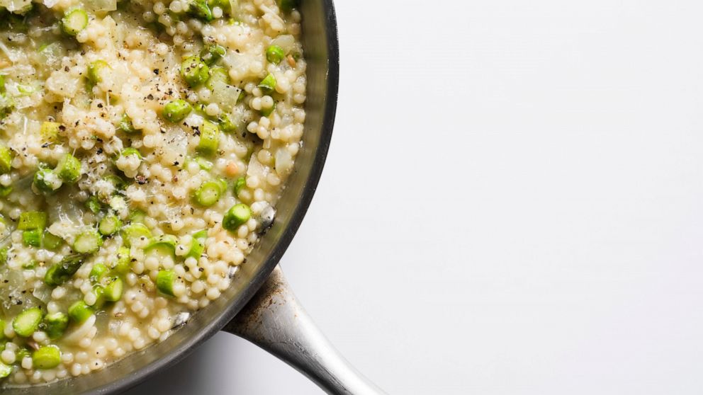 This image released by Milk Street shows a recipe for couscous risotto with asparagus. (Milk Street via AP)