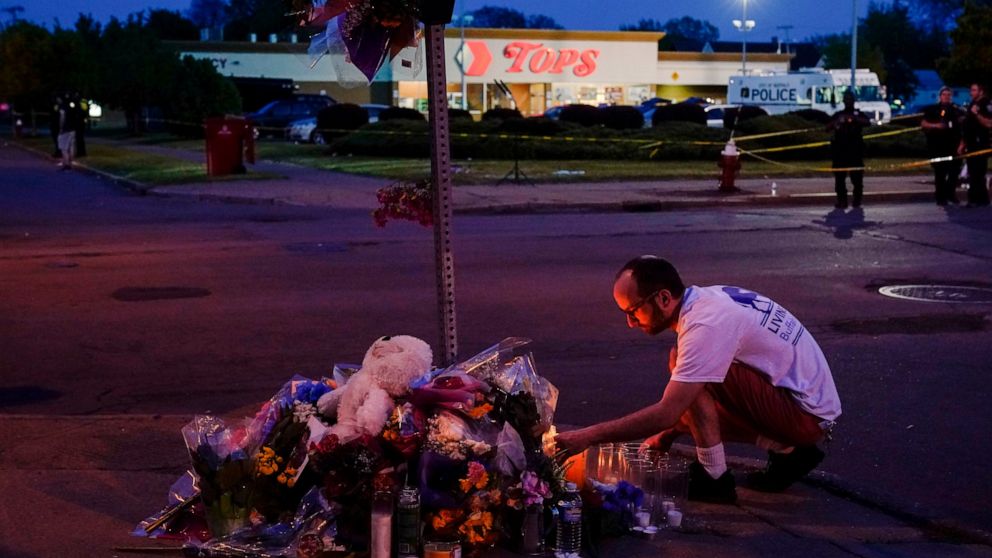FILE - A person pays his respects at a makeshift memorial outside the scene of a shooting at a supermarket in Buffalo, N.Y., Sunday, May 15, 2022. (AP Photo/Matt Rourke, File)