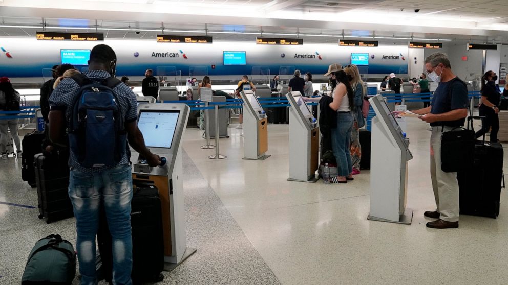 FILE - Travelers use the self-service kiosk to check in and pay for luggage at the American Airlines terminal, Thursday, April 29, 2021, in Miami. Driven in part by pressure for contactless interactions during the pandemic, technology is rapidly evol