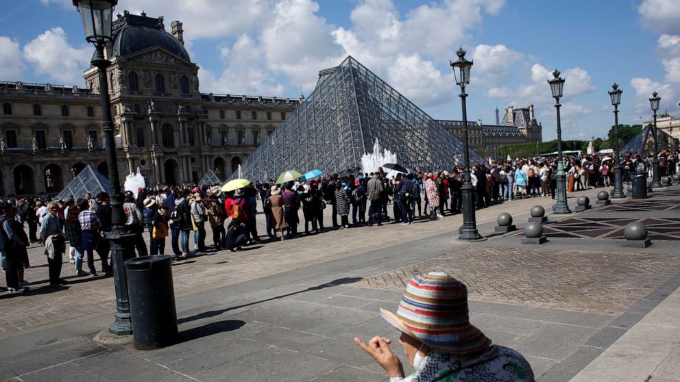Tourists wait in line to visit the Louvre museum as it reopens, in Paris, Wednesday, May, 29, 2019. The world's most visited museum was closed on Monday after employees complained they were harassed by tourists waiting to see the Mona Lisa. (AP Photo