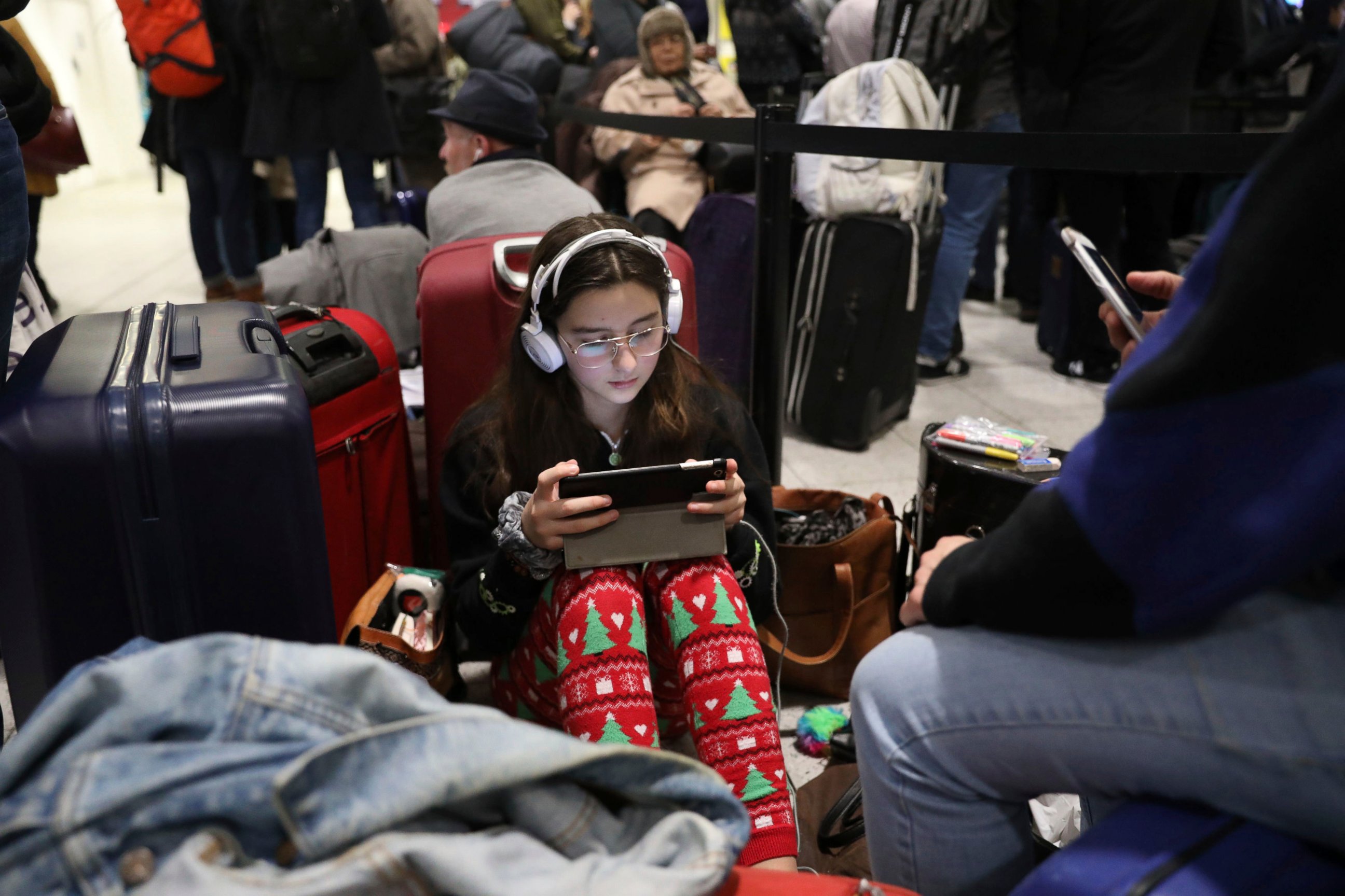 Passengers at Gatwick airport settle down to wait for their flights following the delays and cancellations brought on by drone sightings near the airfield, in London, Friday Dec. 21, 2018. New drone sightings Friday caused fresh chaos for holiday tra