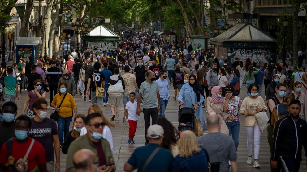 People wearing face masks to protect against the spread of Coronavirus walk along La Rambla in downtown Barcelona, Spain, Saturday, May 15, 2021. (AP Photo/Emilio Morenatti)