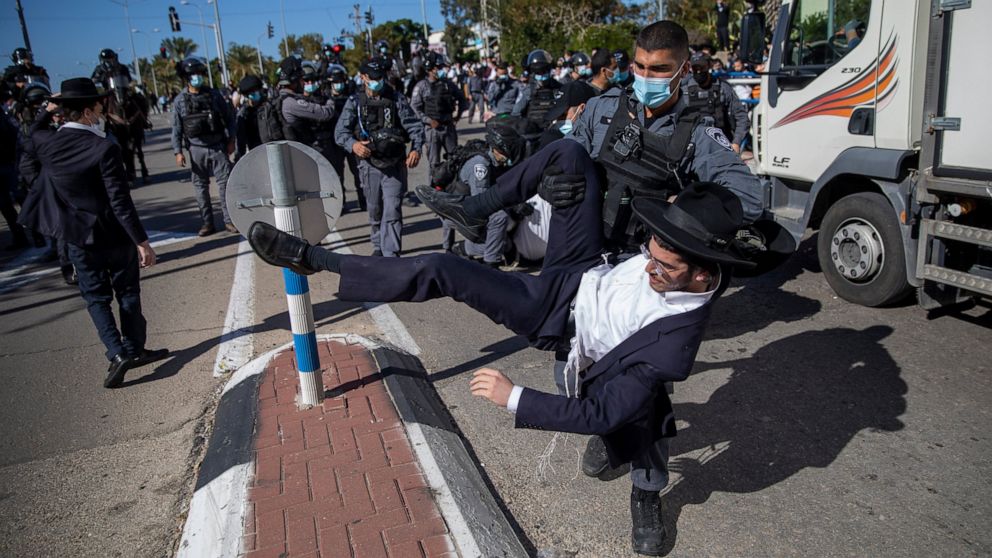 File - In this Sunday, Jan. 24, 2021 file photo, Israeli police officers clash with ultra-Orthodox Jews in Ashdod, Israel,. Ultra-Orthodox demonstrators clashed with Israeli police officers dispatched to close schools in Jerusalem and Ashdod that had