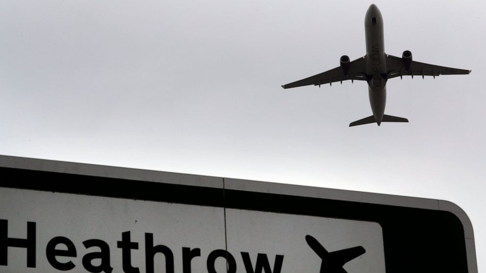 FILE - In this file photo dated Tuesday, June 5, 2018, a plane takes off over a road sign near Heathrow Airport in London. Heathrow Airport officials and union leaders are holding last-ditch talks in hopes of averting a strike at Europe’s busiest air