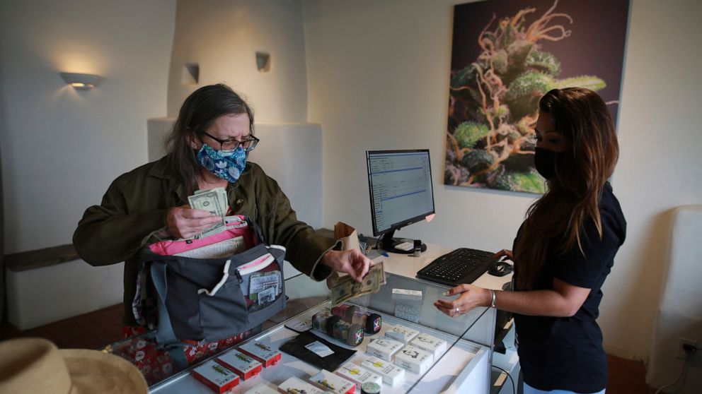 Multiple sclerosis patient and medical marijuana advocate Aurore Bleck buys cannabis at the Minerva medical dispensary on Tuesday, June 29, 2021, in Santa Fe, New Mexico. Marijuana is now legal in New Mexico for recreational use. Black welcomes the l