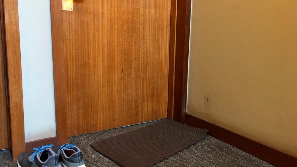 In this April 6, 2020, photo, shoes that are not allowed inside sit outside the door to Associated Press journalist Janelle Cogan's Atlanta home. Her boyfriend is an essential worker in the transportation sector, and because he's not able to work fro