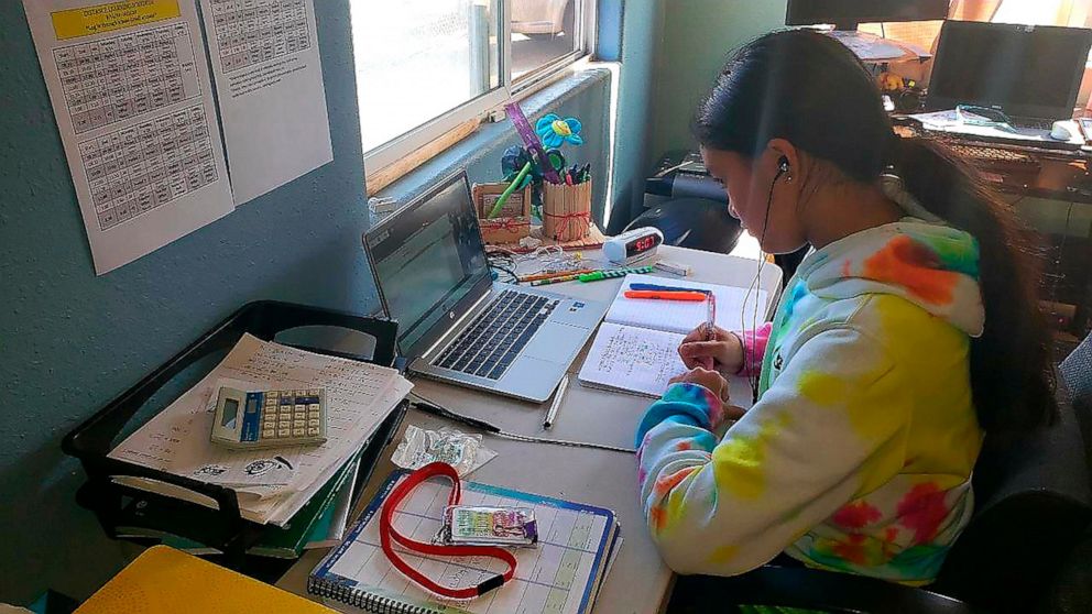 This photo provided by Charles Timtim shows his daughter, name withheld by parents, doing schoolwork from home in Waipahu, Hawaii, Tuesday, Sept. 22, 2020. Timtim's mother doesn't think it's safe for her daughter to be back at school but she also doe