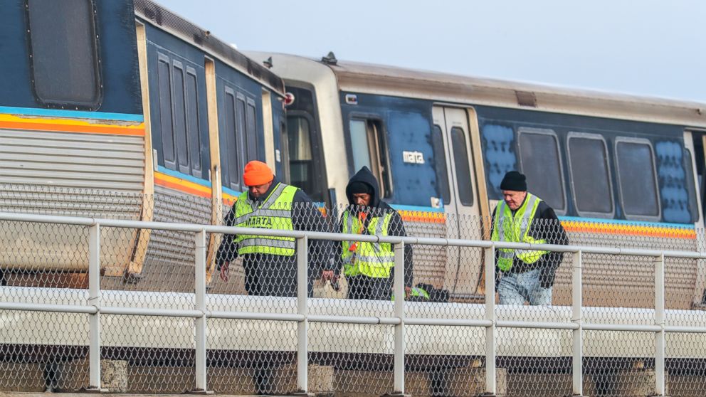 Metropolitan Atlanta Rapid Transit Authority (MARTA) employees inspect an out-of-service train that got stuck on the tracks just north of Hartsfield-Jackson International Airport, Wednesday, Jan. 16, 2019, in Atlanta. Rail Operations Chief Dave Sprin