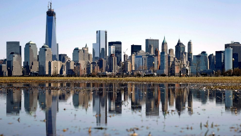 FILE - New York's Lower Manhattan skyline, including the One World Trade Center, left, is reflected in water on April 6, 2013, as seen from Liberty State Park in Jersey City, N.J. Eight of the 10 largest cities in the U.S. lost population during the 