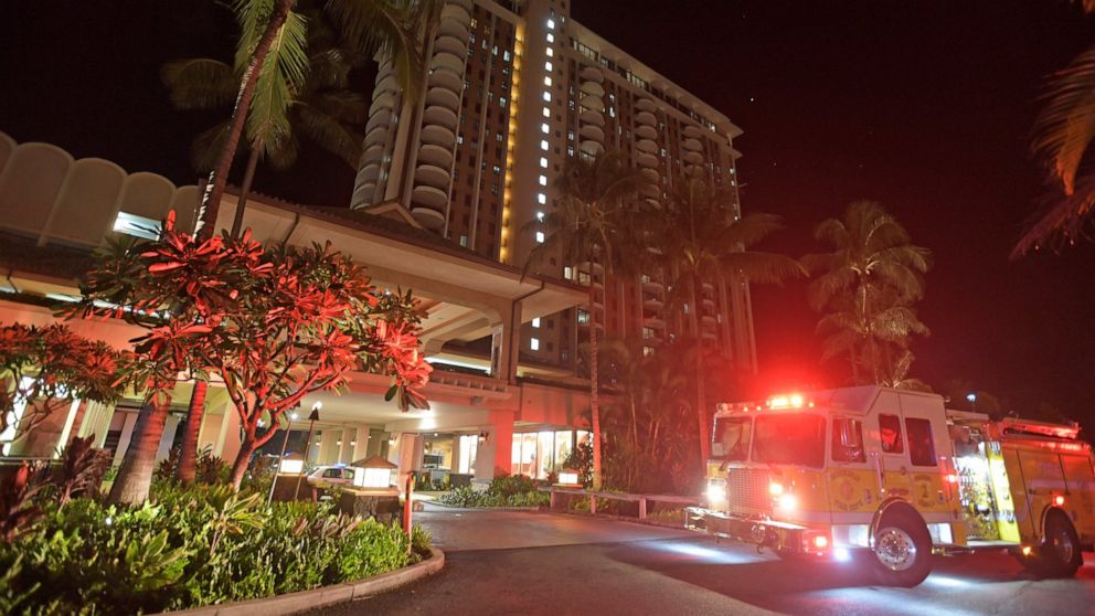 In this Tuesday, Aug. 6, 2019, photo, first responders from Honolulu Fire Department and Honolulu Police Department arrive at the Grand Waikikian in response to a fire reported on the 28th floor, in Honolulu. (Bruce Asato/Honolulu Star-Advertiser via AP)