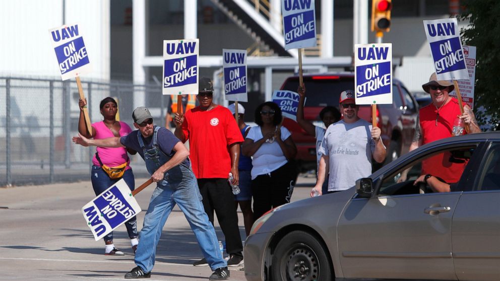 Gary Allison, left, waves while standing with other union members picketing outside the General Motors Plant in Arlington, Texas, Monday, Sept. 16, 2019. More than 49,000 members of the United Auto Workers walked off General Motors factory floors or 