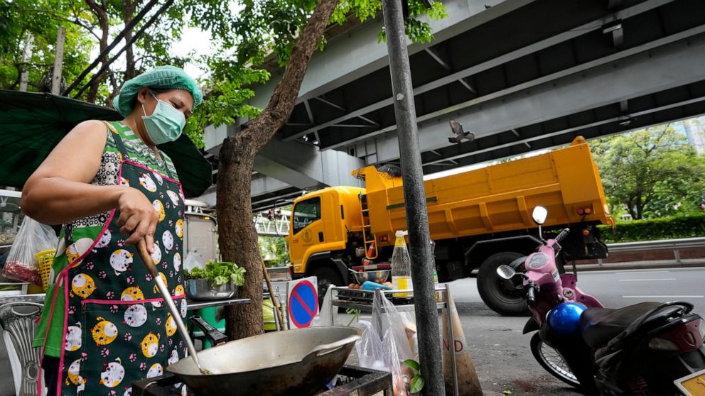 Street food vendor Warunee Deejai cooks lunch for customers in Bangkok, Thailand, Thursday, Aug. 11, 2022. In the six months since Russia invaded Ukraine, the fallout from the war has had huge effects on the global economy. Though intertwined with ot