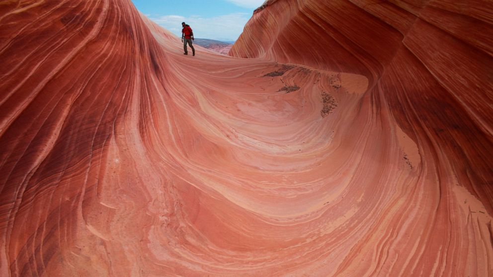 FILE - This May 28, 2013 file photo shows a on a rock formation known as The Wave in the Vermilion Cliffs National Monument in Arizona. A new proposal could mean bigger crowds at one of the most exclusive hiking spots in the southwestern United State