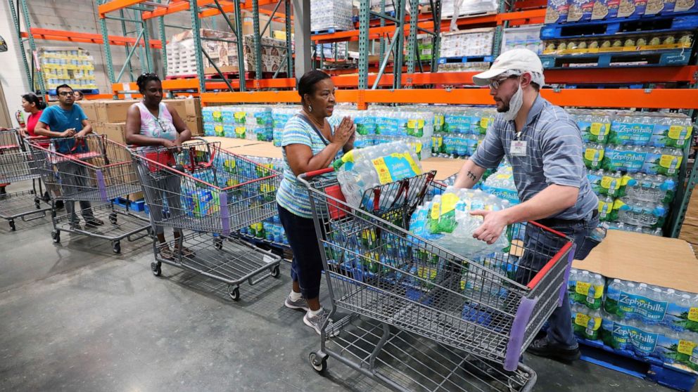 A shopper is grateful to get two cases of bottled water —the limit per customer — at a Costco store in Altamonte Springs, Fla., Friday, Aug. 30, 2019, as central Florida residents prepare for a possible strike by Hurricane Dorian. (Joe Burbank/Orland