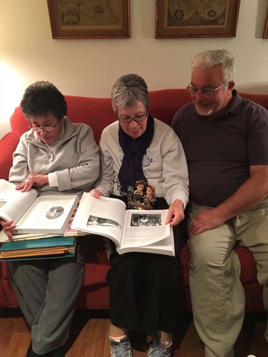 PHOTO: Siblings Sylvia Faison Graves Kewer, Billy Lee Ray, and Nancy Goode O'Donnell look at an old photo album on Nov. 12, 2017.
