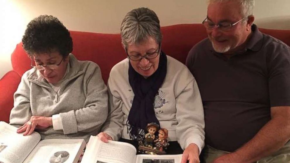 PHOTO: Siblings Sylvia Faison Graves Kewer, Billy Lee Ray, and Nancy Goode O'Donnell look at an old photo album on Nov. 12, 2017.
