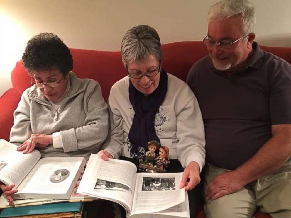 PHOTO: Siblings Sylvia Faison Graves Kewer, Billy Lee Ray, and Nancy Goode ODonnell look at an old photo album on Nov. 12, 2017.