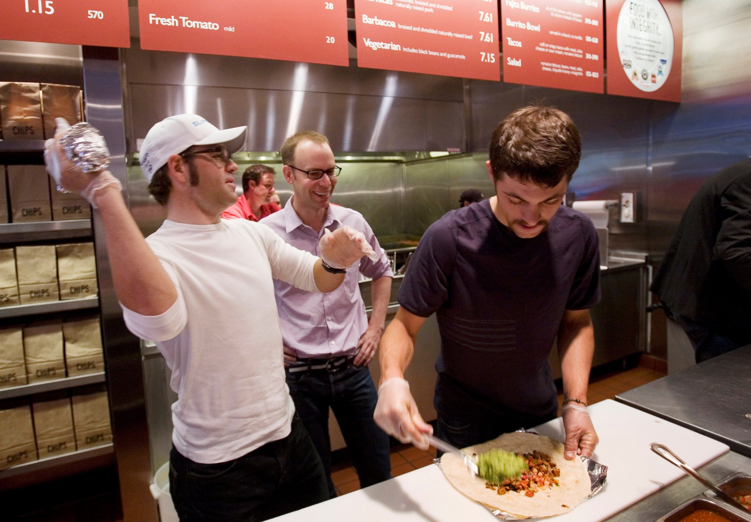 PHOTO: Mike Friedman, left, a rider with Slipstream-Chipotle, makes burritos with  teammate Steven Cozza, right, and Steve Ells, center, CEO of Chipotle Mexican Grill,  June 6, 2008 in New York. 
