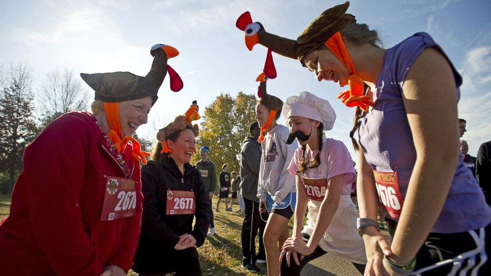 Dressed as turkeys and a chef, three generations of runners from the same family including, from left, Becky Arrambide, Laura Arrambide, Kat Lancaster, Sara Lancaster and Gabby Arrambide, stretch before participating in the annual Memphis Turkey Trot race in Memphis, Tenn., Nov. 22, 2012.