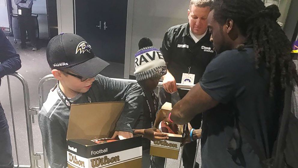 PHOTO: Baltimore Ravens star Alex Collins gives autographed footballs to Carl Tubbs, 12, and Miles Tubbs, 10.