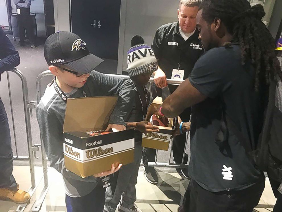 PHOTO: Baltimore Ravens star Alex Collins gives autographed footballs to Carl Tubbs, 12, and Miles Tubbs, 10.