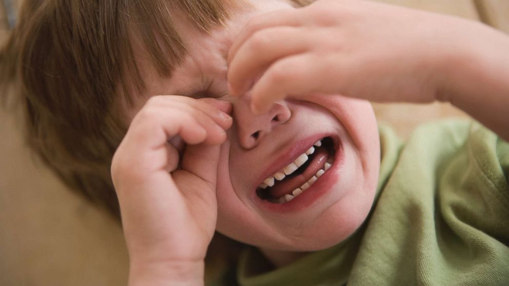 A young boy crying with his hands covering his face having a tantrum in this undated stock photo. 