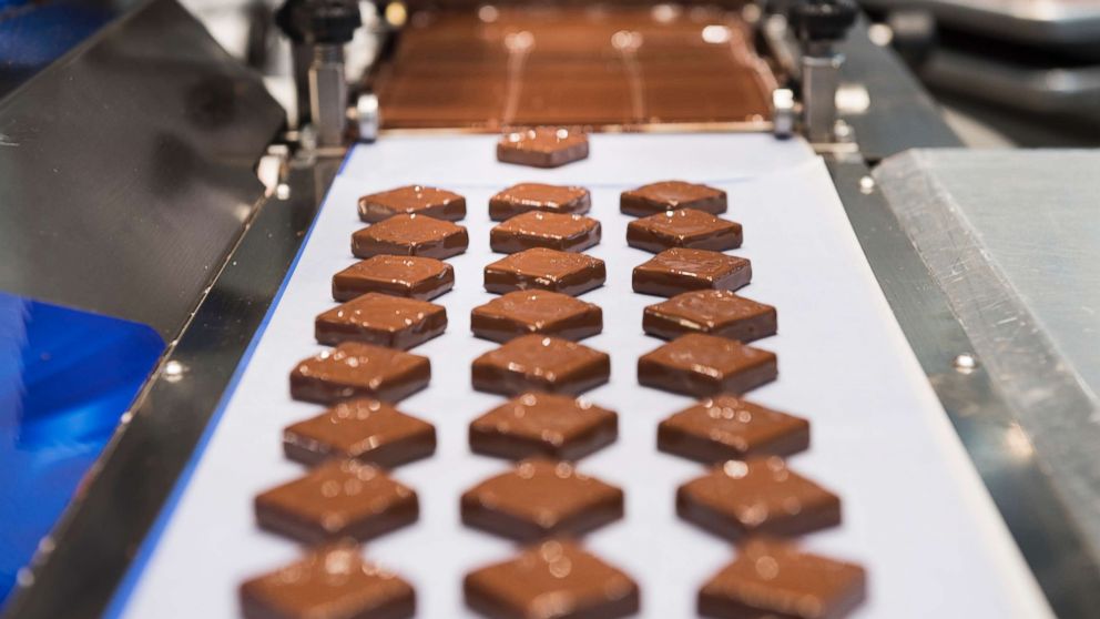 PHOTO: At Kreuther Handcrafted Chocolate, an enrobing machine at work making specialty chocolates. 