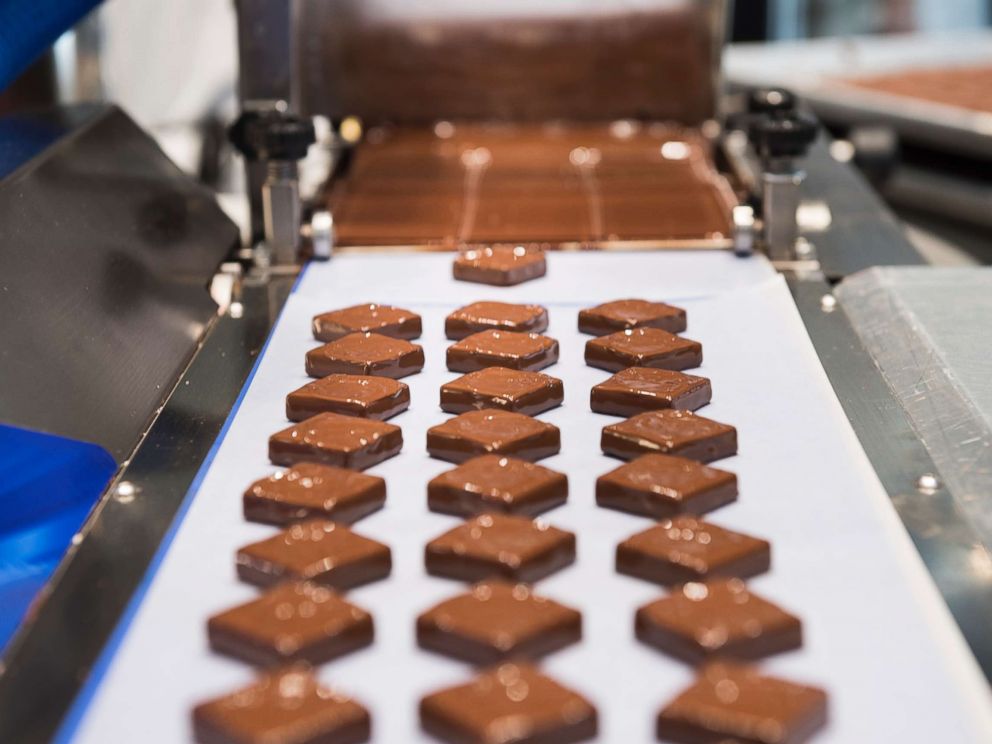 PHOTO: At Kreuther Handcrafted Chocolate, an enrobing machine at work making specialty chocolates.